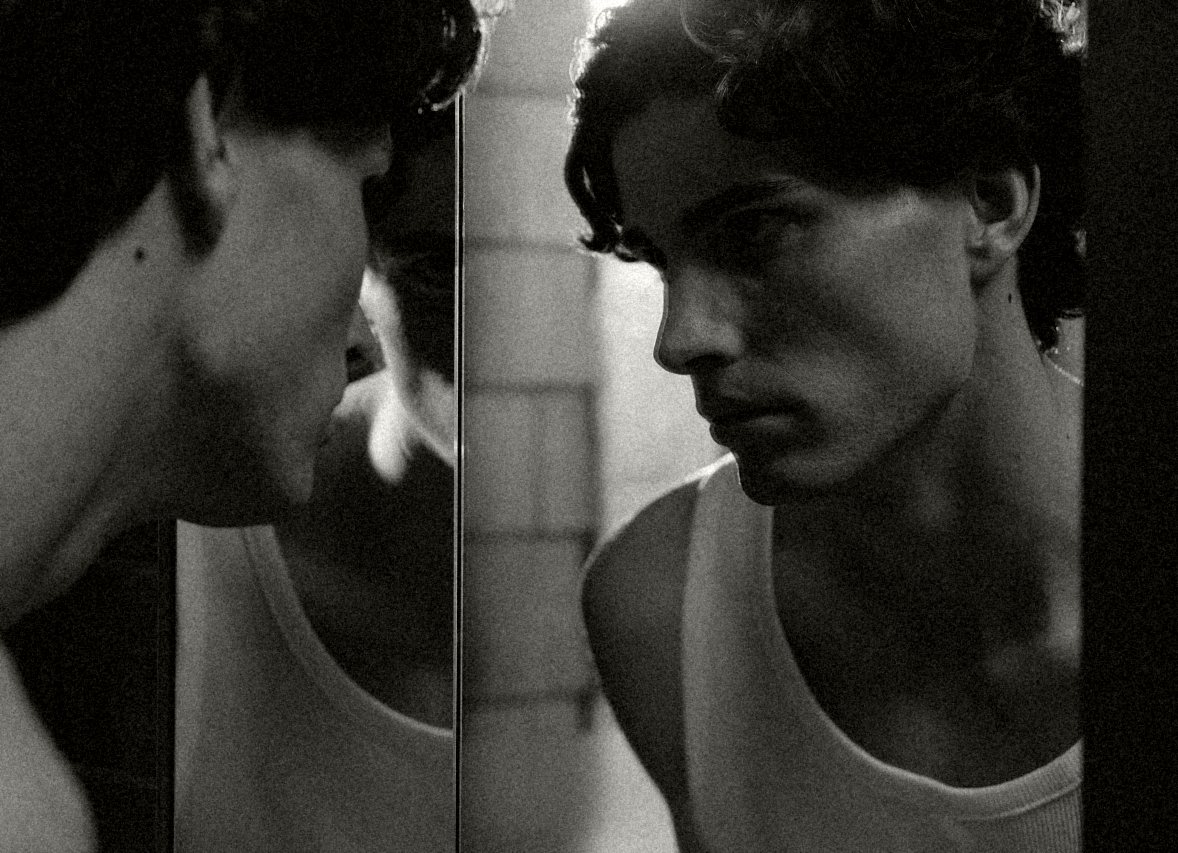 Man looking at himself in a bathroom mirror